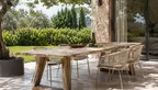 Großer Gartentisch aus recyceltem Teakholz auf einer Terrasse mit Garten.