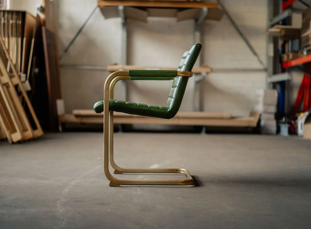 Leder Freischwinger mit Armlehnen aus Messing und Leder.