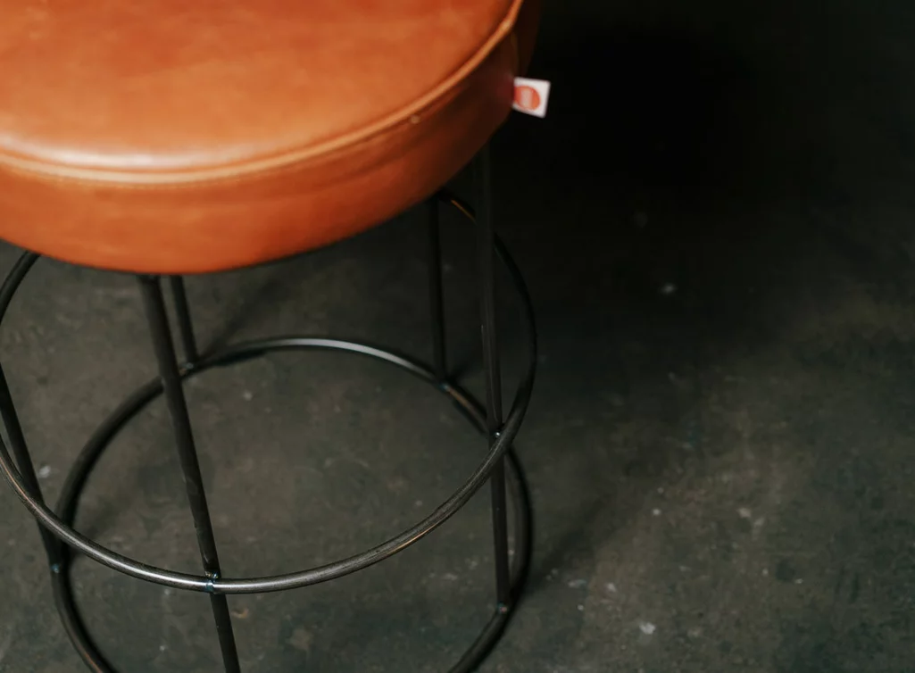 Lederhocker mit einem Untergestell aus Stahl in der Oberfläche Old Glory - Modell Cody