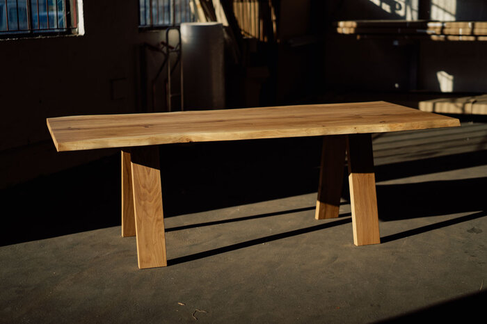 Baumtisch aus massiver Eiche mit Astanteil und Baumkanten gefertigt.