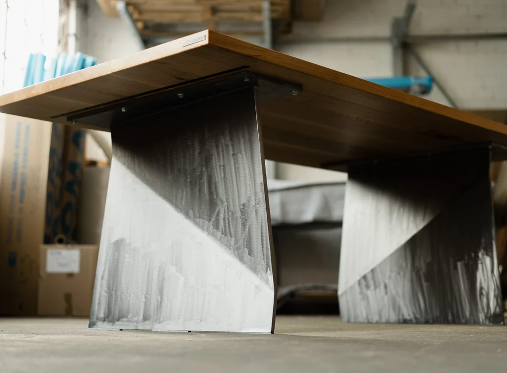 Massiver Holztisch mit Metallwangen Untergestell im futuristischen Design