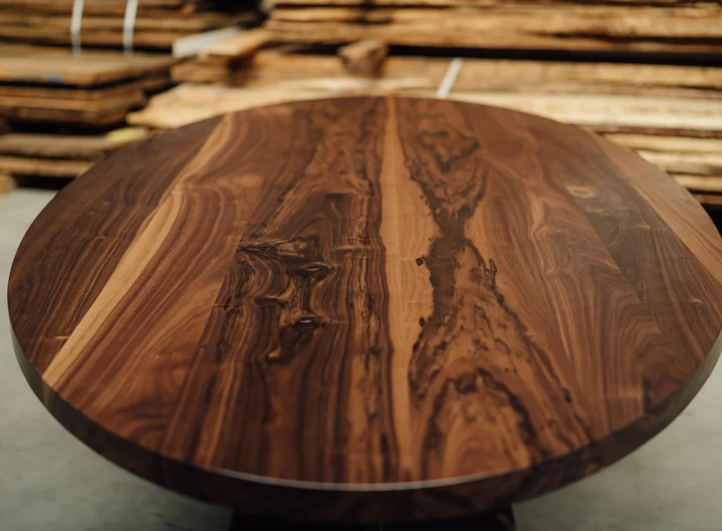 Ovaler Esstisch aus Nussbaum massiv mit Stahlgestell - Tischplatte mit Astanteil