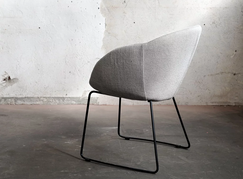 Schalenstuhl mit einem Stoffbezug und Metallbeinen