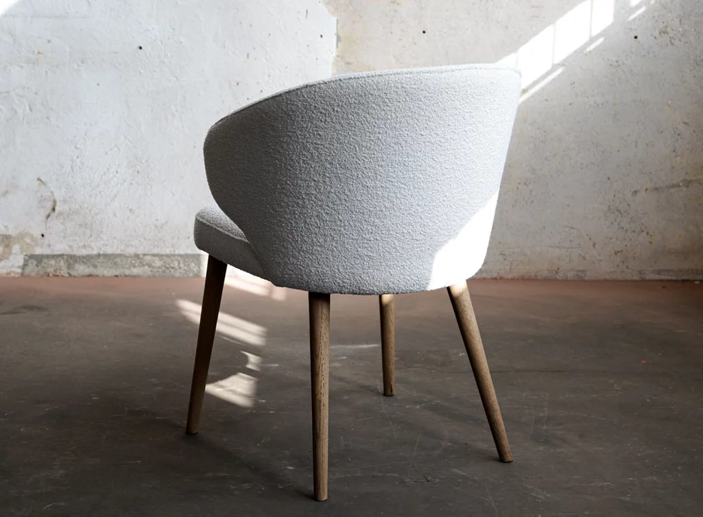 Stoffstuhl mit einer stylischen Sitzschale und Massivholz Beinen